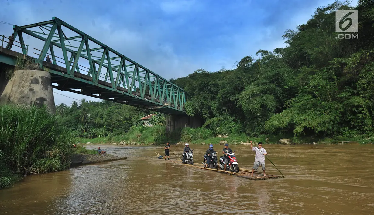 Pengendara roda dua memanfaatkan jasa perahu rakit untuk menyeberangi Sungai Cisadane di Rumpin, Bogor, Selasa (13/3). Akibat rusaknya jembatan akses  utama Rumpin-Ciseeng, warga menaiki perahu rakit dengan tarif Rp10.000. (Merdeka.com/Arie Basuki)
