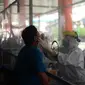 Paramedis melakukan pengambilan sampel spesimen terhadap salah seorang warga yang beraktivitas di Pasar Raya.