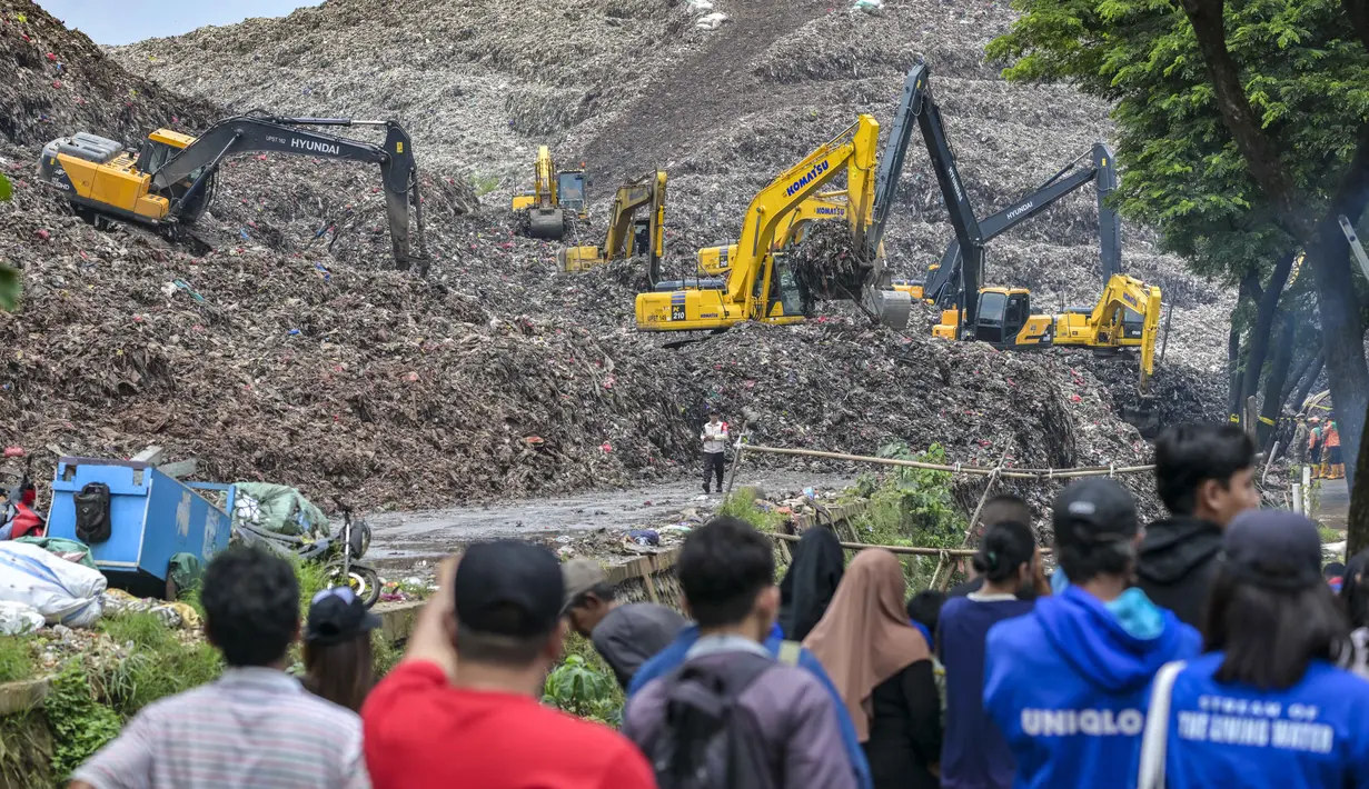 Insiden yang terjadi pada Minggu 8 Maret 2026, mengakibatkan setidaknya lima orang meninggal dunia tertimbun material longsoran di lokasi kejadian. Tampak dalam foto, tim penyelamat menggunakan alat berat untuk mencari korban longsor di Tempat Pembuangan Sampah Terpadu (TPST) Bantargebang, Bekasi, Jawa Barat, pada 9 Maret 2026. (BAY ISMOYO/AFP)