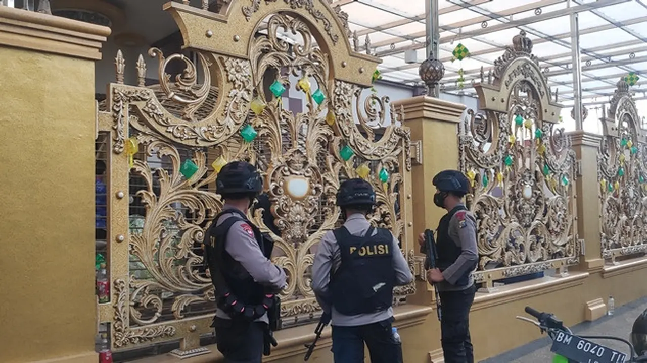 Polisi bersenjata lengkap bersiaga di rumah mewah Kampung Narkoba saat penggeledahan dilakukan.