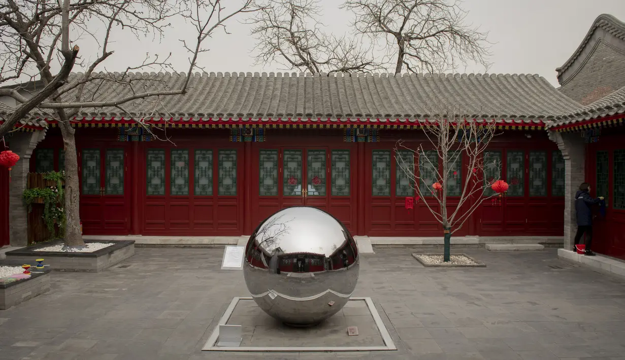 Seorang pekerja membersihkan jendela museum Dongsi Hutong di Beijing (26/2). Sejak pertengahan abad ke-20, sejumlah besar hutong Beijing dihancurkan untuk membuka jalan bagi jalan dan bangunan baru. (AFP Photo/Nicolas Asfouri)