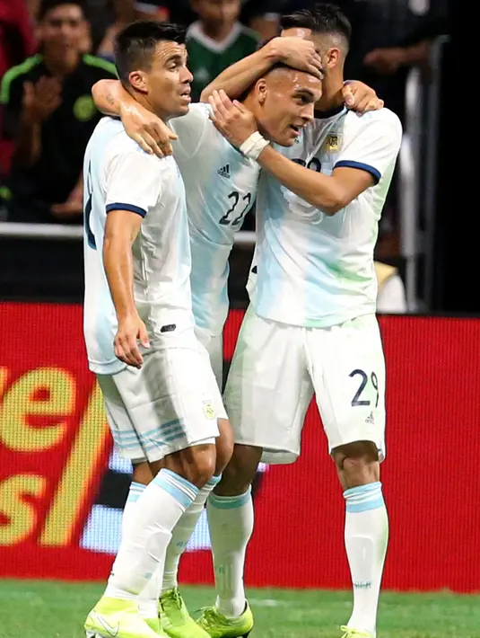 Penyerang Argentina Lautaro Martinez (tengah) disambut oleh rekan setimnya Marcos Acuna dan Ezequiel Palacios setelah mencetak gol ke gawang Meksiko dalam laga persahabatan di Alamodome, San Antonio, Texas, Amerika Serikat, Selasa (10/9/2019). (Edward A. Ornelas/Getty Images North America/AFP)