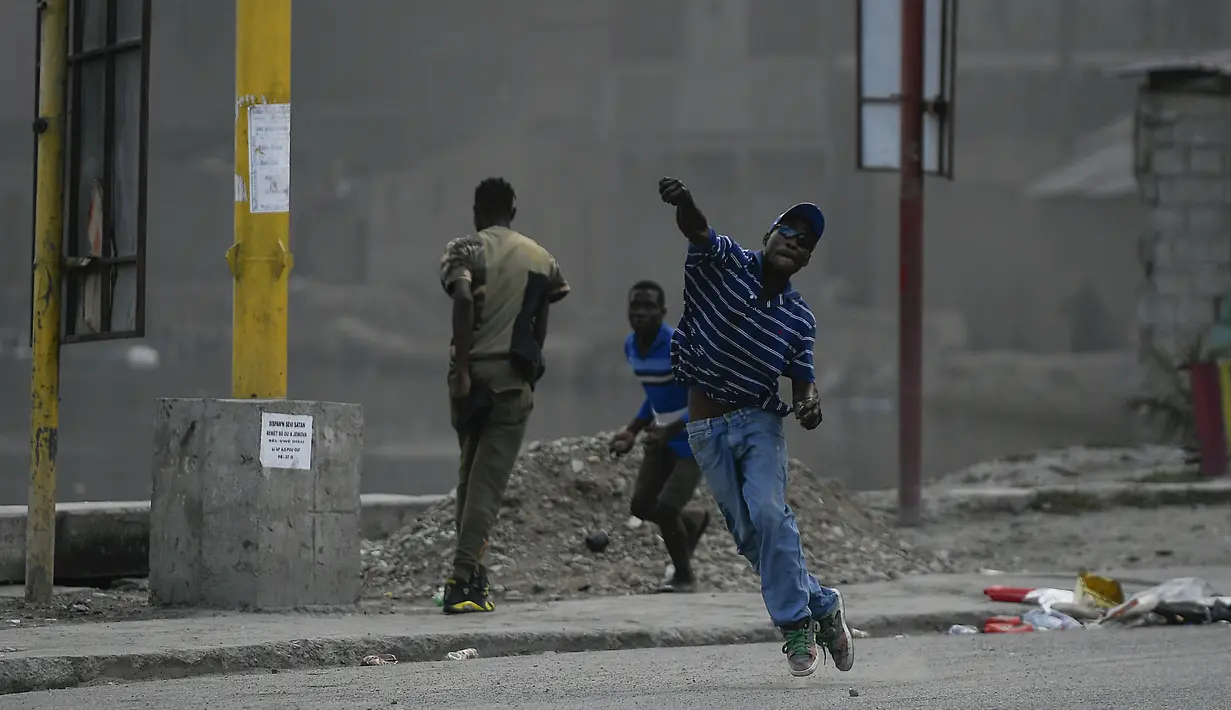 Demonstran melemparkan batu saat menuntut keadilan atas pembunuhan Presiden Haiti Jovenel Moise di Cap-Haitien, Haiti, Kamis (22/7/2021). Demonstrasi menuntut keadilan atas pembunuhan Presiden Haiti Jovenel Moise terus berlanjut dan menimbulkan kerusuhan. (AP Photo/Matias Delacroix)