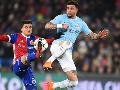 Bek Manchester City, Kyle Walker (kanan) berebut bola dengan pemain Basel, Mohamed Elyounoussi pada laga 16 besar Liga Champions di Saint Jakob-Park Stadium, Basel, (13/2/2018). Manchester City menang 4-0. (AFP/Sebastian Bozon)
