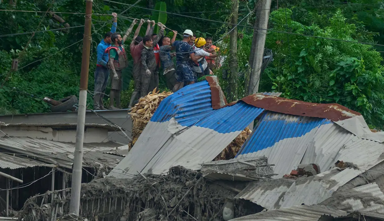 Tim penyelamat membentangkan tali saat evakuasi korban selamat setelah banjir bandang di sepanjang Sungai Trishuli di distrik Nuwakot, Nepal, Rabu, 26 Agustus 2026. (Foto AP/Niranjan Shrestha)