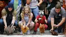Para peserta bersiap melepaskan ayam betina jagoannya dalam World Hen Racing Championships di Bonsall, Inggris, Sabtu (1/8/2015). Sejumlah ayam betina adu kecepatan untuk menjadi pemenang dalam kejuaran tersebut. (Reuters/Darren Staples)