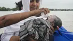 Diluwara Begum, seorang bidan, menggendong bayi yang baru lahir setelah membantu persalinannya di atas perahu di atas Sungai Brahmaputra, di negara bagian Assam, India timur laut, Rabu, 3 Juli 2024. (AP Photo/Anupam Nath)