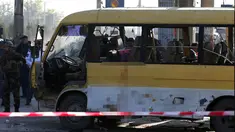 Petugas keamanan dan pemadam kebakaran saat mengecek kondisi minibus yang terkena serangan bunuh diri di Kabul, Afghanistan, Senin (20/6). Sebanyak 14 orang tewas akibat serangan ini. (REUTERS / Omar Sobhani)
