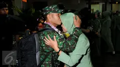 Personel TNI AD yang tergabung dalam kontingen AASAM mencium kening pasangannya saat penyambutan kedatangan di Bandara Soetta, Banten, Senin (23/5/2016). TNI AD menjadi juara umum AASAM 2016 yang digelar di Australia. (Liputan6.com/Helmi Fithriansyah)