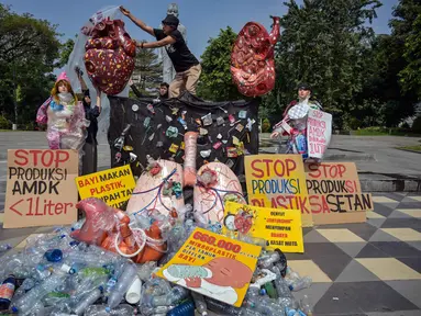 Aktivis dari Ecological Observation and Wetlands Conservation (ECOTON) dan mahasiswa memasang instalasi berbentuk jantung dan paru-paru yang rusak akibat terpapar sampah mikroplastik dalam sebuah protes untuk meningkatkan kesadaran akan dampak plastik sekali pakai terhadap lingkungan dan kesehatan manusia di Surabaya, Rabu 16 Juli 2025. (Juni KRISWANTO/AFP)