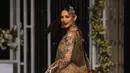 Aktris Neelam Muneer mengenakan busana rancangan desainer Dnnus Dlrar selama Pantene Hum Bridal Couture Week di Lahore, Minggu (9/12). Kreasi gaun pengantin yang ditampilkan didominasi kain sari yang menjadi ciri khas wanita Pakistan. (ARIF ALI / AFP)
