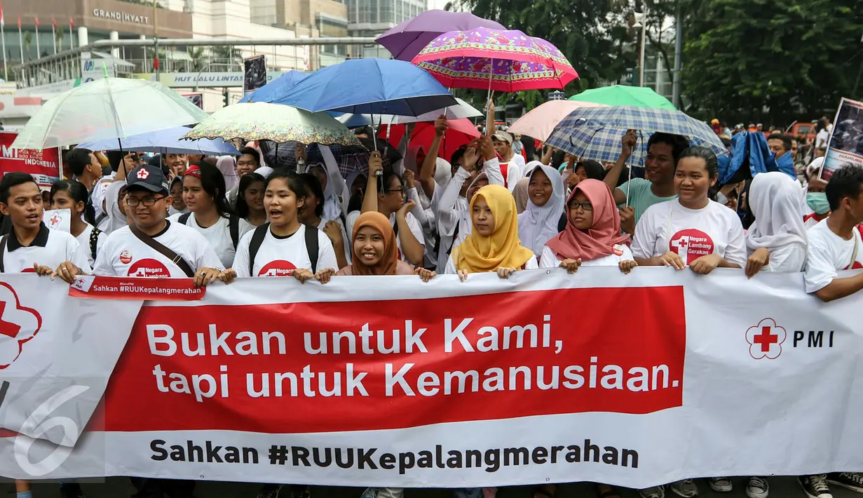 Sejumlah sukarelawan PMI membawa spanduk dan poster meminta DPR untuk segera mengesahkan RUU kepalangmerahaan menjafi UU kepalangmerahaan di Bunderan HI, Jakarta, Minggu (6/3). (Liputan6.com/Yoppy Renato)