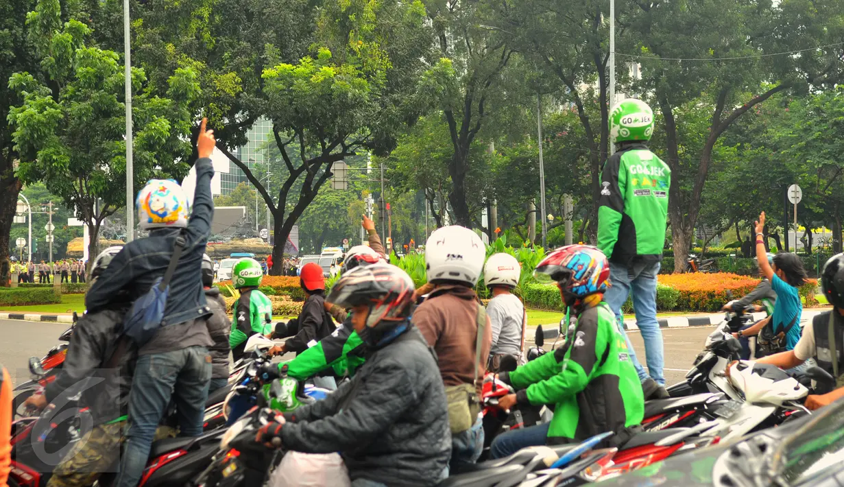 Pengemudi ojek online terlibat aksi lempar batu dengan sopir taksi yang melakukan unjuk rasa, di kawasan Sudirman, Jakarta, Selasa (22/3). Aksi itu pecah saat pengunjuk rasa mendapat perlawan dari pengemudi ojek online. (Liputan6.com/Faisal R Syam)