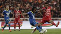 Gelandang Persija Jakarta, Yan Pieter, berebut bola dengan pemain Persib Bandung pada laga Shopee Liga 1 di SUGBK, Jakarta, Rabu (10/7). Persija bermain imbang 1-1 atas Persib. (Bola.com/Yoppy Renato)