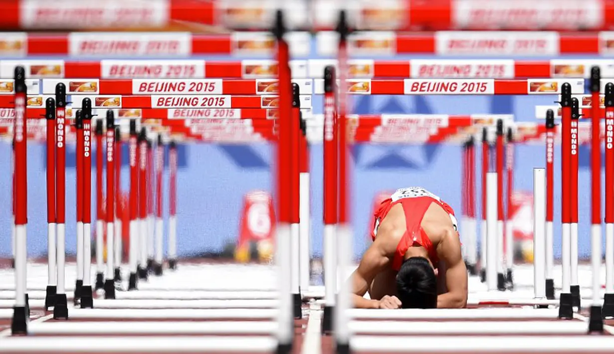 Kesedihan pelari Tiongkok, Zhang Honglin, setelah terjatuh dalam nomor lari gawang 110m putra Kejuaraan Dunia Atletik 2015 di Stadion Nasional, Beijing, Tiongkok. (26/8/2015). (AFP Photo/Olivier Morin)