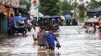 Sejumlah warga melintasi banjir di kawasan Loudi, provinsi Hunan (2/7). Curah hujan yang tinggi membuat air sungai Xiangjiang meluap dan mengakibatkan banjir di provinsi Hunan. (AFP Photo/Str/China Out)