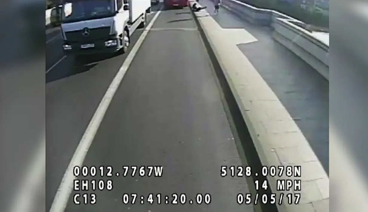 Seorang wanita terjatuh usai didorong pria tak dikenal di Jembatan Putney di London (8/8). Polisi Inggris telah meminta saksi untuk membantu menemukan pelari yang mendorong seorang wanita ke jalur bus. (Polisi Metropolitan via AP)