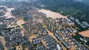 Sebelumnya dilaporkan 80.900 orang mengungsi akibat banjir yang melanda daerah Rongjiang, Guizhou, barat daya China sejak Selasa 24 Juni 2025. Tampak dalam foto udara yang menunjukkan bangunan-bangunan yang terendam banjir di Rongjiang, provinsi Guizhou barat daya China pada 24 Juni 2025. (AFP/China OUT)