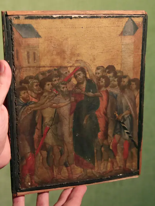 Pakar seni Stephane Pinta memperlihatkan lukisan “Christ Mocked” karya seniman Cimabue dari abad ke-13 di Paris, 24 September 2019. Lukisan berukuran 20 x 26 cm (10 inci) itu, diyakini sebagai bagian dari diptych yang terdiri dari delapan panel kecil. (AP/Michel Euler)