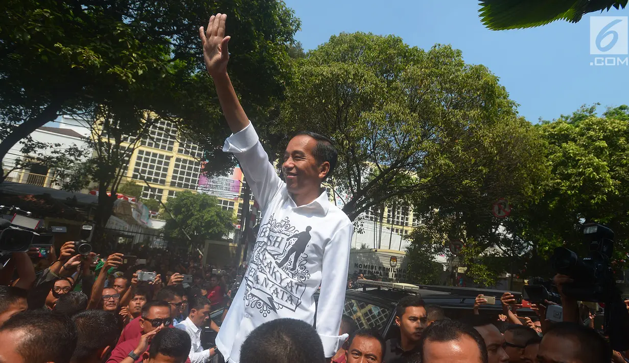 Presiden Joko Widodo menyapa pendukungnya usai mendaftarkan Capres-Cawapres ke Komisi Pemilihan Umum (KPU), Jakarta, Jumat (10/8). Jokowi dan Ma'ruf Amin resmi sebagai capres-cawapres untuk Pilpres 2019. (Merdeka.com/Imam Buhori)