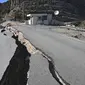 Retakan besar terlihat di jalan dekat pusat gempa, di distrik Pazarcik, kota Kahramanmaras, Turki pada Kamis 16 Februari 2023 setelah terjadinya gempa berkekuatan 7,8 magnitudo menghantam beberapa wilayah di Turki dan Suriah pada 6 Februari lalu. (OZAN KOSE/AFP)