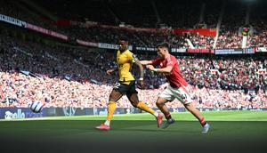 Pemain Manchester United, Harry Amass (kanan) membayangi pergerakan pemain Wolves, Nelson Semedoduring dalam laga lanjutan Liga Inggris 2024/2025 di Old Trafford, Inggris, Minggu (20/04/2025) waktu setempat. (AFP/Paul Ellis)