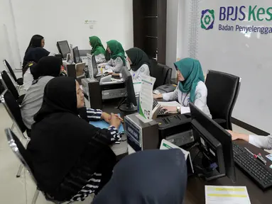 Petugas melayani warga yang mengurus iuran BPJS Kesehatan di Kantor BPJS Jalan Raya Pasar Minggu, Jakarta, Senin (4/11/2019). Perhimpunan Rumah Sakit Seluruh Indonesia memprediksi akan terjadi migrasi turun kelas pada peserta akibat kenaikan iuran 100 persen pada awal 2020. (merdeka.com/Arie Basuki)