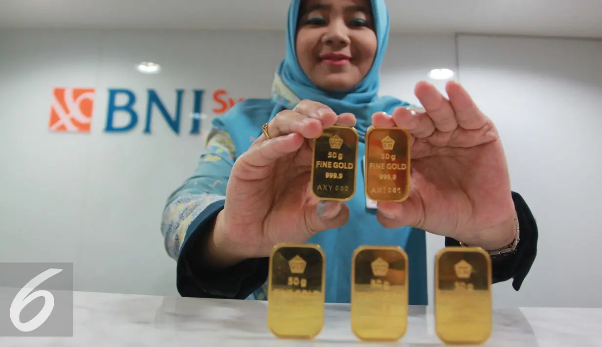 Petugas menunjukan emas batangan di Jakarta, Rabu (13/7). Harga emas batangan atau Logam Mulia milik PT Aneka Tambang Tbk (Antam) hari ini dibuka turun Rp 10.000/gram. (Liputan6.com/Angga Yuniar) 