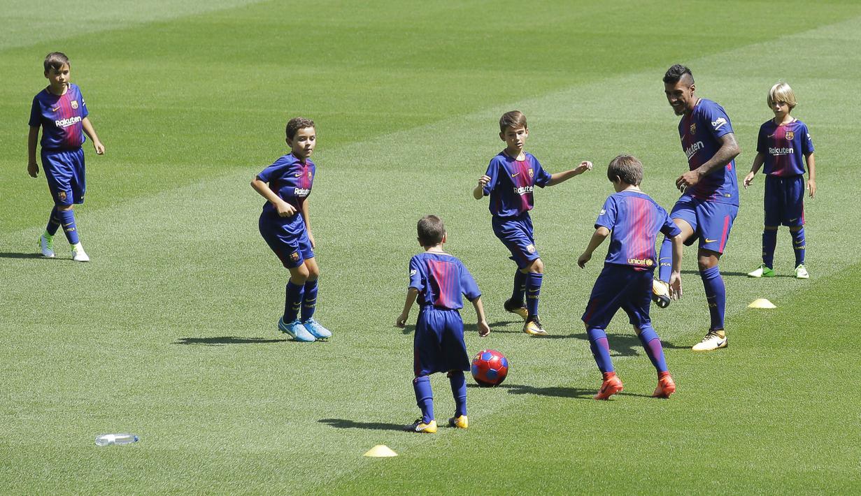 Gelandang baru Barcelona, Paulinho, bermain bola bersama anak-anak saat diperkenalkan di Stadion Camp Nou, Kamis (17/7/2017). Pria asal Brasil ini resmi berseragam Barcelona setelah ditebus dari Guangzhou Evergrande. (AP/Manu Fernandez)