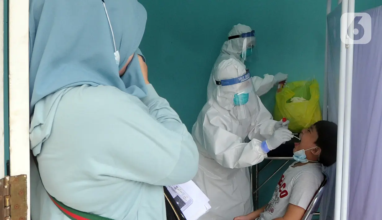 Paramedis melakukan swab test PCR kepada seorang anak di Puskesmas Kramat Jati, Jakarta Timur, Rabu (13/1/2020). Setiap harinya, Puskesmas Kramat Jati menyediakan kuota 300 swab test PCR  secara gratis untuk memutus mata rantai penyebaran COVID-19. (merdeka.com/Arie Basuki)