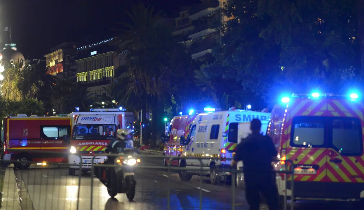 Petugas kepolisian dan kendaraan medis dikerahkan ke lokasi serangan teror truk di Nice, Prancis, Kamis (14/7). Setidaknya 60 orang tewas saat sebuah truk menabrak kerumunan ramai yang merayakan libur nasional Bastille Day. (REUTERS/ Jean-Pierre Amet)