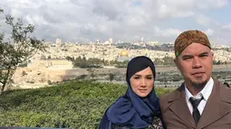 Penyanyi Mulan Jameela dan Ahmad Dhani foto bersama dengan latar Masjid Al Aqsa dari Bukit Zaitun, Yerusalem. Ahmad Dhani menyebut wisata religinya dengan sang istri sebagai bulan madu. (Instagram/@mulanjameela1)