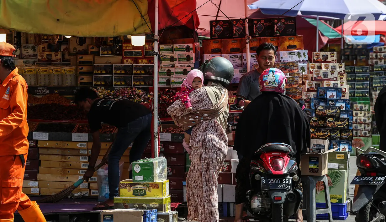 Pengendara berhenti di salah satu kios pedagang kurma di kawasan Tanah abang, Jakarta, Minggu (3/4/2022). Omset penjualan kebutuhan bulan Ramadhan seperti perlengkapan ibadah dan buah kurma kembali meningkat dibandingkan dua tahun terakhir yang terdampak pandemi COVID-19. (Liputan6.com/Johan Tallo)
