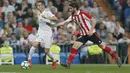 Pemain Real Madrid, Lucas Vazquez (kiri) mengecoh pemain Athletic Bilbao, Raul Garcia pada lanjutan La Liga Santander di Santiago Bernabeu stadium, Madrid, (18/4/2018). Real Madrid bermain imbang 1-1 dengan Bilbao. (AP/Francisco Seco)