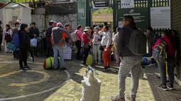 Orang-orang berkumpul di luar stasiun kereta kota Machu Picchu, Peru untuk berangkat setelah kedatangan kereta pertama menyusul perpanjangan layanan dari Ollantaytambo, Rabu (8/2/2023). Layanan kereta api ke Machu Picchu di Peru sebagian diaktifkan kembali Rabu ini untuk mengangkut penduduk lokal, setelah penangguhan hampir tiga minggu karena blokade rel kereta api akibat protes anti-pemerintah yang mengguncang negara Andes. (Carolina Paucar / AFP)