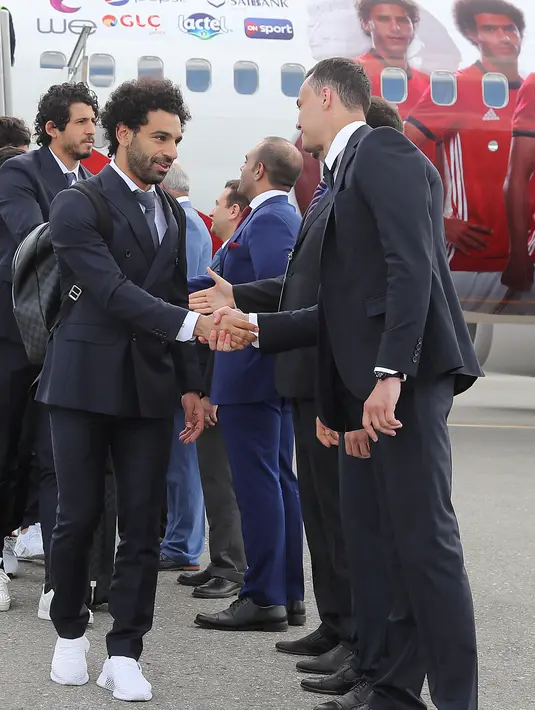 Penyerang Timnas Mesir, Mohamed Salah bersalaman saat tiba di Bandar Udara Internasional Grozny, Rusia (10/6). Pemain Liverpool ini masih dalam masa pemulihan cedera bahu yang dideritanya pada final Liga Champions. (AFP Photo/Karim Jaafar)