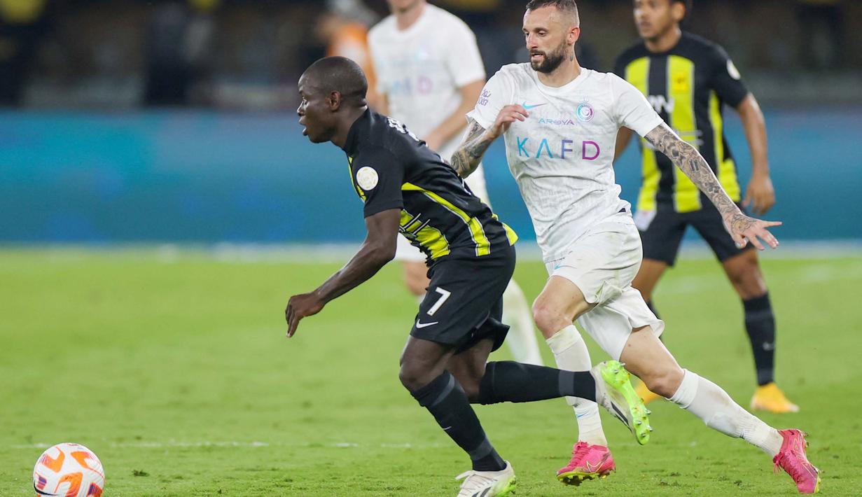 Pemain Al Ittihad, N'Golo Kante, berusaha melewati pemain Al Nassr, Marcelo Brozovic, dalam laga tunda pekan ke-17 Liga Arab Saudi di King Abdullah Sport City Stadium, Jeddah, Rabu (27/12/2023). (Photo by AFP)