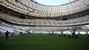Seorang pria bekerja di lapangan Lusail Stadium, Lusail, Qatar, 28 Maret 2022. Stadion berkapasitas 80 ribu penonton yang terletak di pinggiran Ibu Kota Doha ini akan menjadi tuan rumah final Piala Dunia 2022 pada bulan Desember mendatang. (GABRIEL BOUYS/AFP)