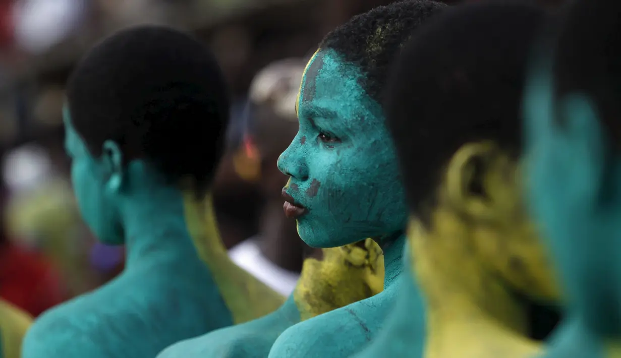 Anak - anak diwarnai sekujur tubuhnya dengan cat untuk mengikuti parade Popo (topeng) dalam karnaval Bonoua , di timur Abidjan, Pantai Gading, (9/4). (REUTERS / Luc Gnago)