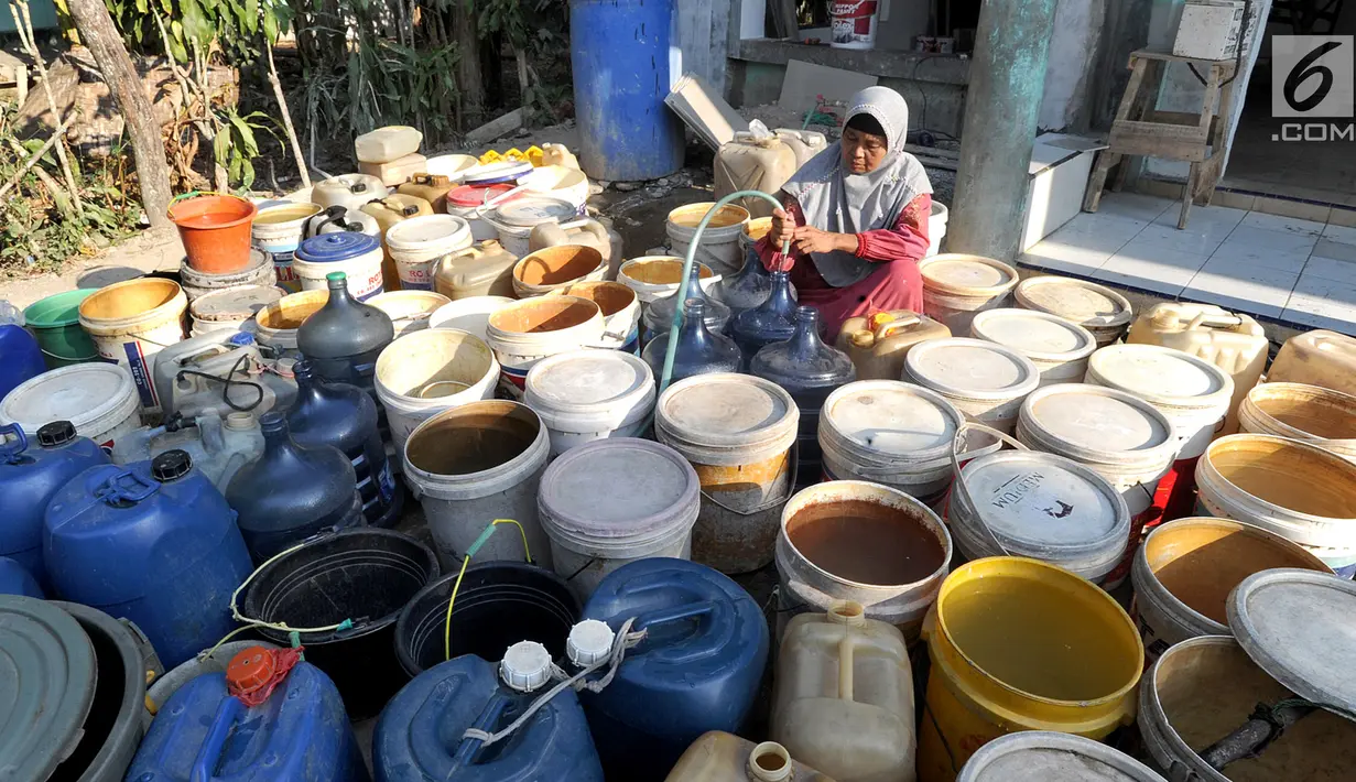 Seorang ibu mengisi air pada antrean jeriken di sumur Masjid  di Kampung Citapen, Desa  Weninggalih, Bogor, Rabu (24/07/2019). Sekitar 4000 jiwa warga Desa Weninggalih mengalami kesulitan mendapatkan air bersih akibat musim kemarau sejak tiga bulan terakhir. (merdeka.com/Arie Basuki)