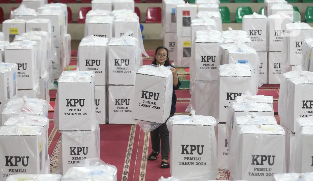 Petugas mengangkat kotak surat suara Pemilu 2024 di GOR Cempaka Putih, Jakarta, Selasa (6/2/2024). (merdeka.com/Imam Buhori)