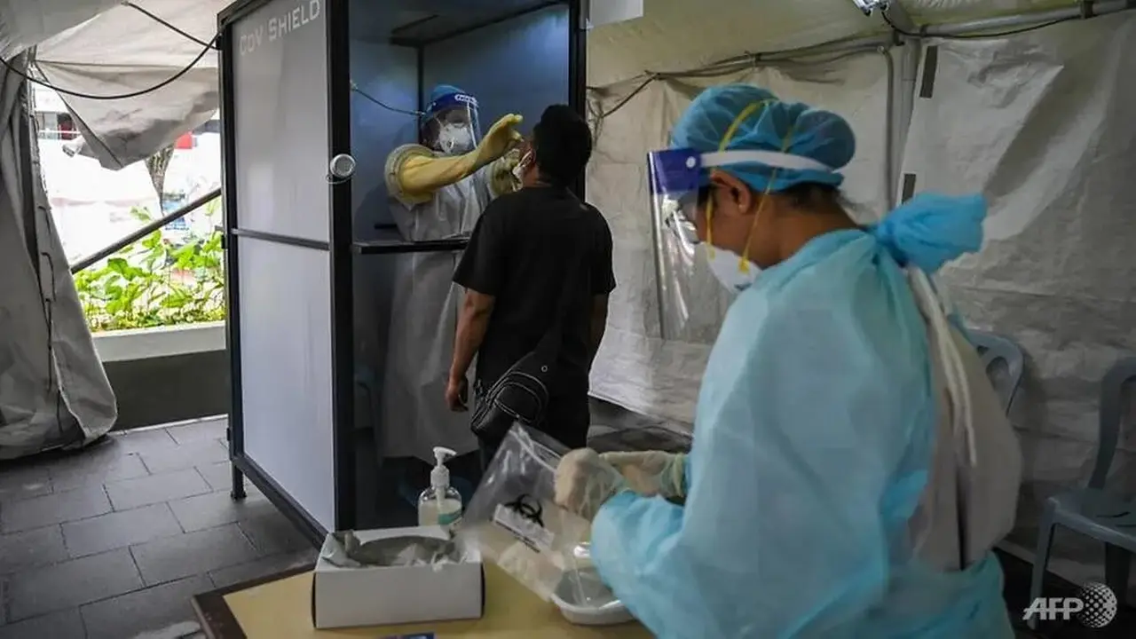 Seorang petugas kesehatan berdiri di dalam ruang non-kontak saat mengumpulkan sampel swab dari seorang pria untuk diuji COVID-19 di Sunway Medical Center di Subang Jaya, Malaysia pada 22 Oktober 2020.