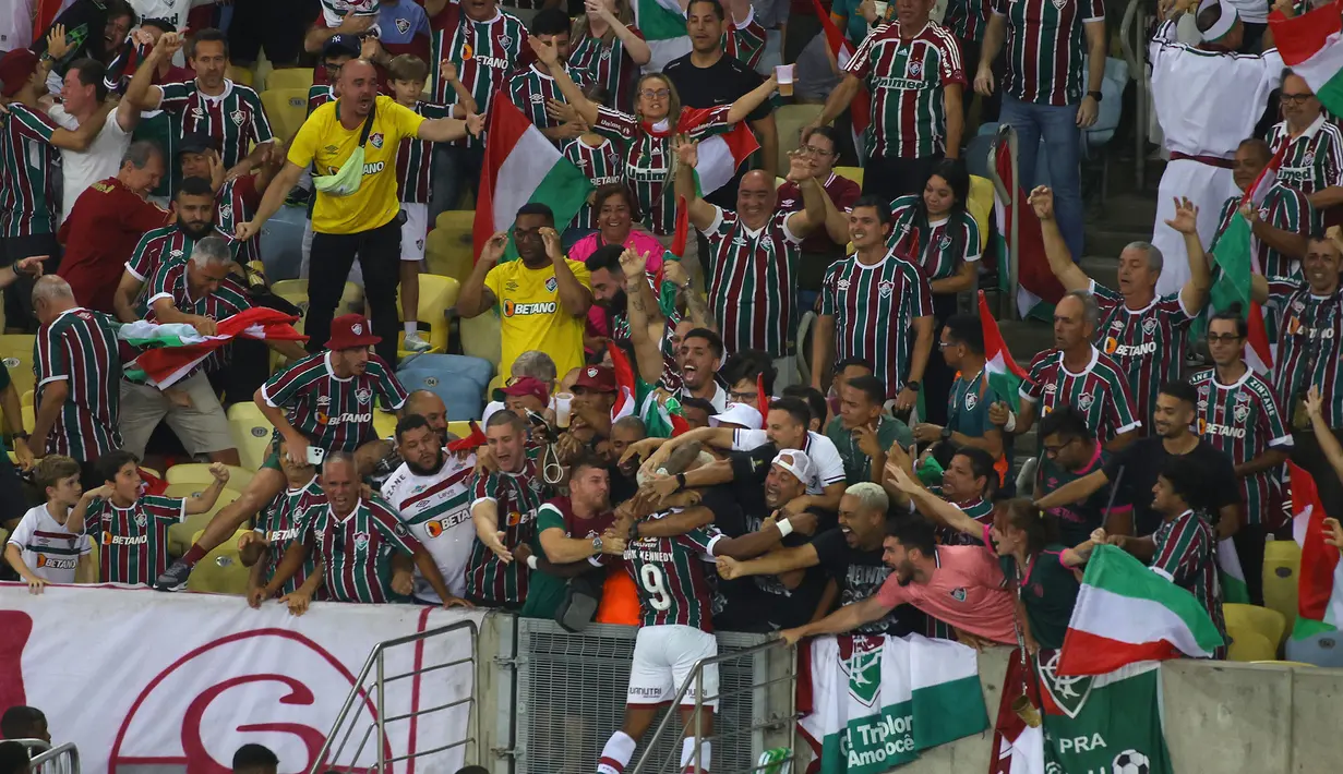 Pemain Fluminense, John Kennedy melakukan selebrasi bersama para pendukung timnya setelah mencetak gol ke gawang Boca Juniors pada final Copa Libertadores yang berlangsung di Maracana Stadium , Rio de Janeiro, Brasil, 5 November 2023 WIB. (AFP/Silvio Avila)