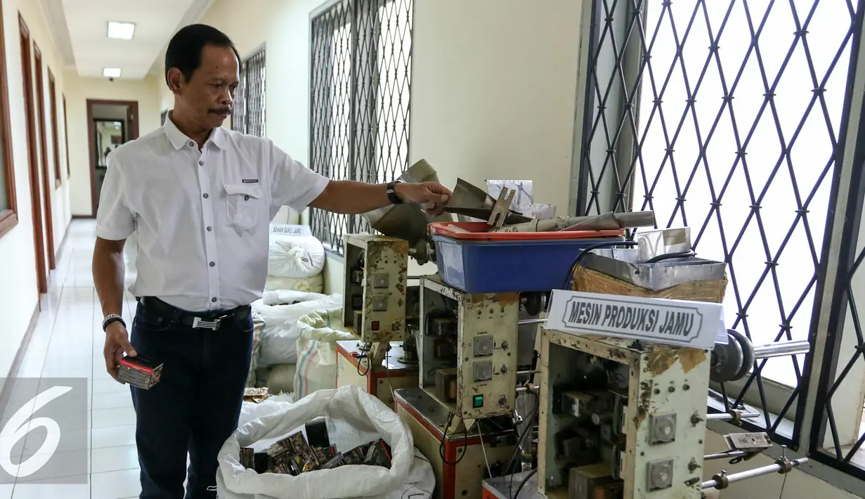 Petugas menunjukan barang bukti jamu dan mesin produksi jamu yang mengandung Bahan Kimia Obat (BKO) di Direktorat Tindak Pidana Narkoba Bareskrim Polri, Jakarta, Senin (7/3/2016). (Liputan6.com/Yoppy Renato)
