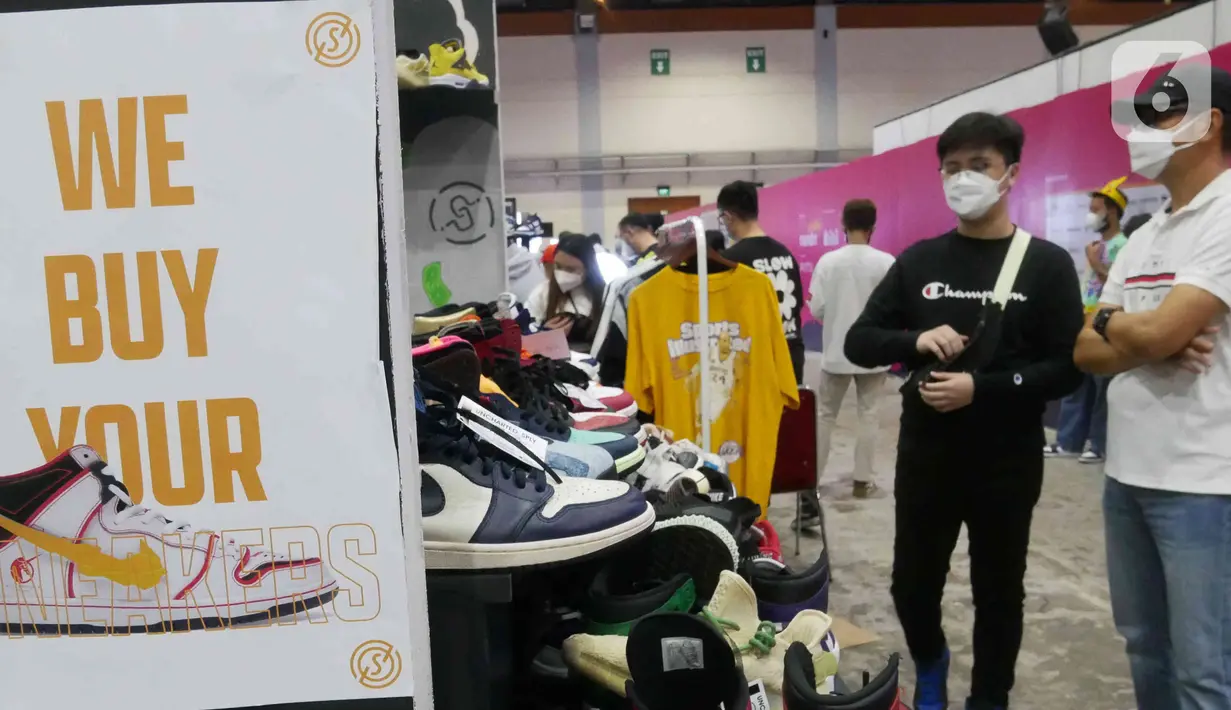 Pengunjung memilih produk yang ditawarkan di Urban Sneaker Society 2021 di JCC, Senayan, Jakarta, Minggu (5/12/2021). Urban Sneaker Society kali ini menghadirkan berbagai brand lokal pilihan mulai dari Streetwear Brand, Sneaker Market, Thrift. (Liputan6.com/Herman Zakharia)