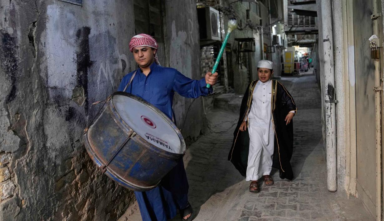 Mesaharati dilakukan secara sukarela demi menjaga semangat ibadah di bulan suci Ramadan. Tampak dalam foto, Wissam Ali, seorang "mesaharati" atau penyeru subuh berusia 22 tahun, saat membangunkan orang-orang untuk makan sebelum matahari terbit, selama bulan suci Ramadan, di lingkungan miskin distrik Fadhil di Baghdad, Irak, Senin 23 Februari 2026. (AP Photo/Hadi Mizban)