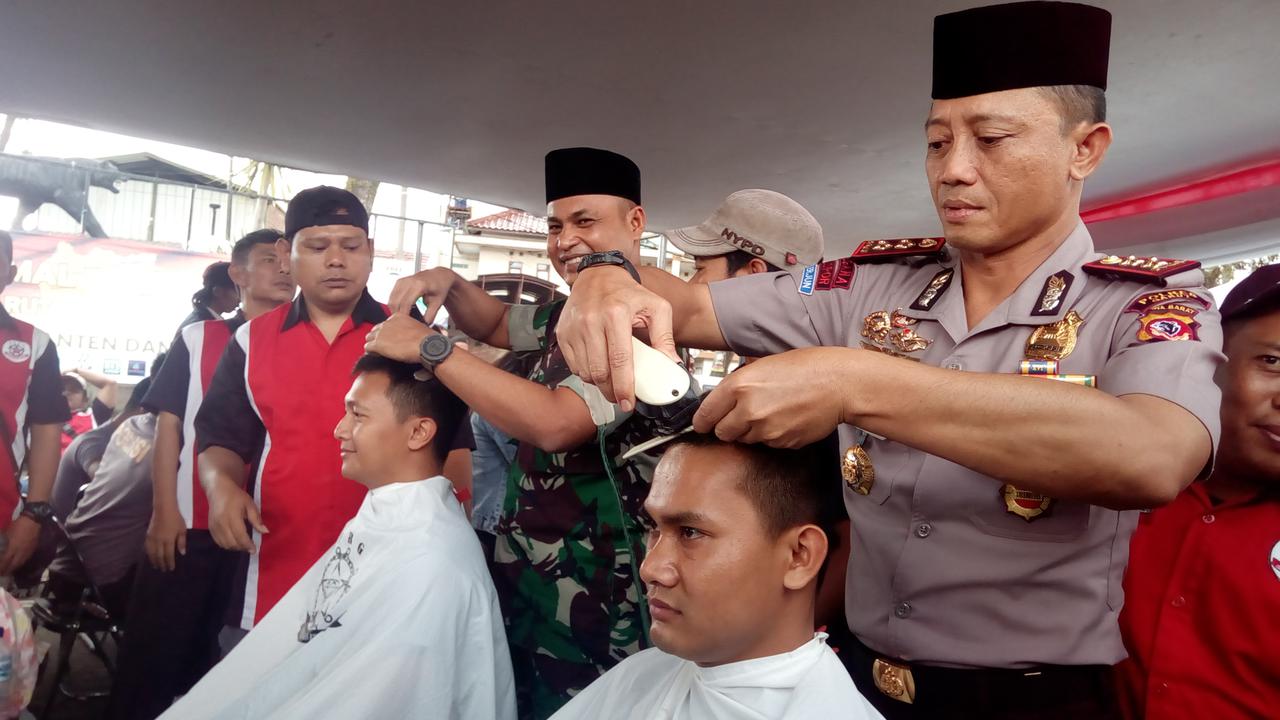Nampak Kapolres Budi terlihat lihat memotong salah satu rambut salah satu anggota polres Garut, dalam penggalangan dana korban tsunami Selat Sunda siang tadi