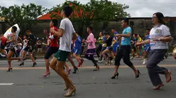 Antusias peserta berlari menggunakan sepatu high heels saat acara "Tour De Takong" di Marikina, Manila, Filipina, 26 November 2016. Balap lari itu bagian dari festival sepatu tahunan di wilayah yang dikenal sebagai ibu kota sepatu. (REUTERS/Ezra Acayan)