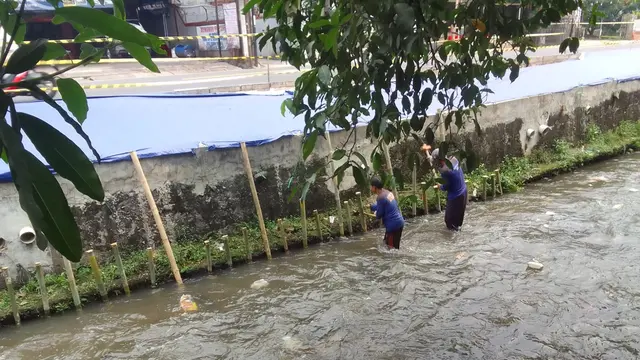 Satgas DPUPR melakukan perbaikan trotoar yang ambles di Jalan Raya Sawangan, Depok. (Liputan6.com/Dicky Agung Prihanto)