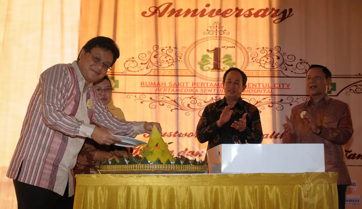 Presiden Direktur Rumah Sakit Pertamedika Sentul City (RSPSC), dr Dani (kiri) secara simbolis memotong tumpeng saat perayaan hari jadi RSPSC ke-1, Sentul, Selasa (28/10/2014). (Liputan6.com/Helmi Fithriansyah)